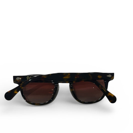 Tortoiseshell sunglasses with dark lenses on a white background
